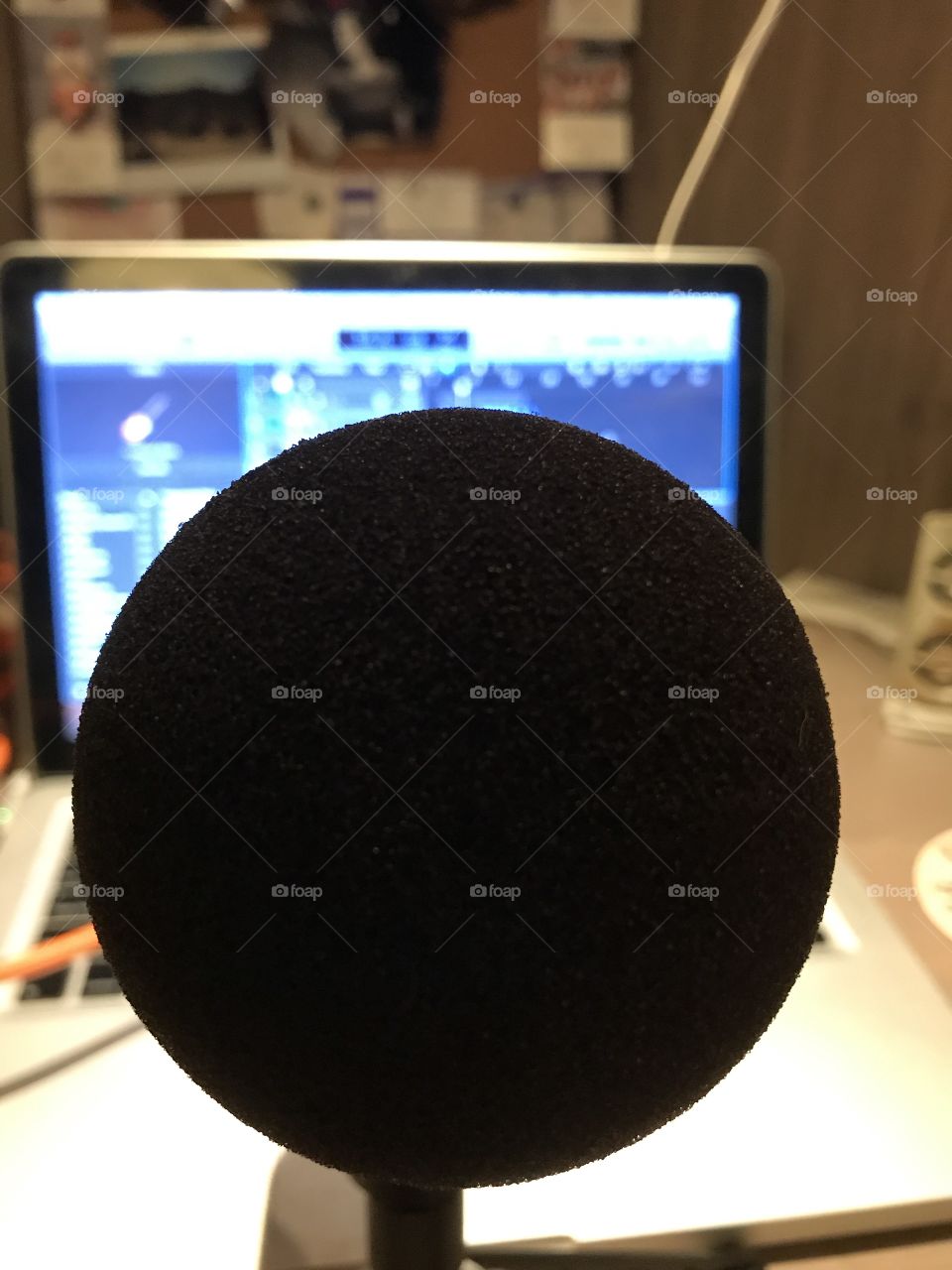 Close up of microphone in front of studio computer at desk 