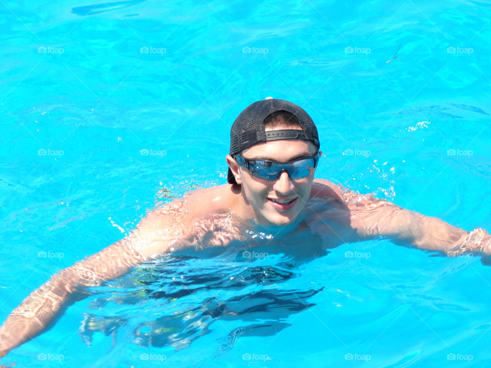 Happy man swimming in pool