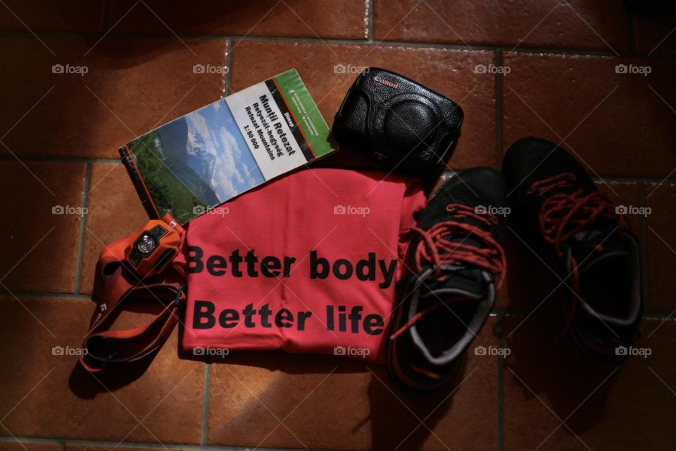 Camera, boots, map, light and motivational t-shirt prepared for holiday 