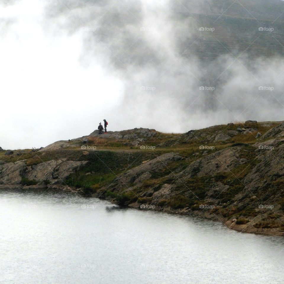 Backpacker in front of the lake in Mont-de-lans in France