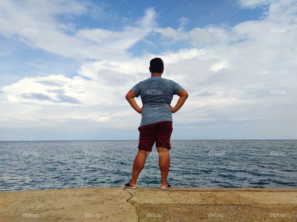 This is a friend of mine taking powerful pose while looking at the sky and beautiful sea which is located in Blue Lagoon Consolacion Cebu Philippines.