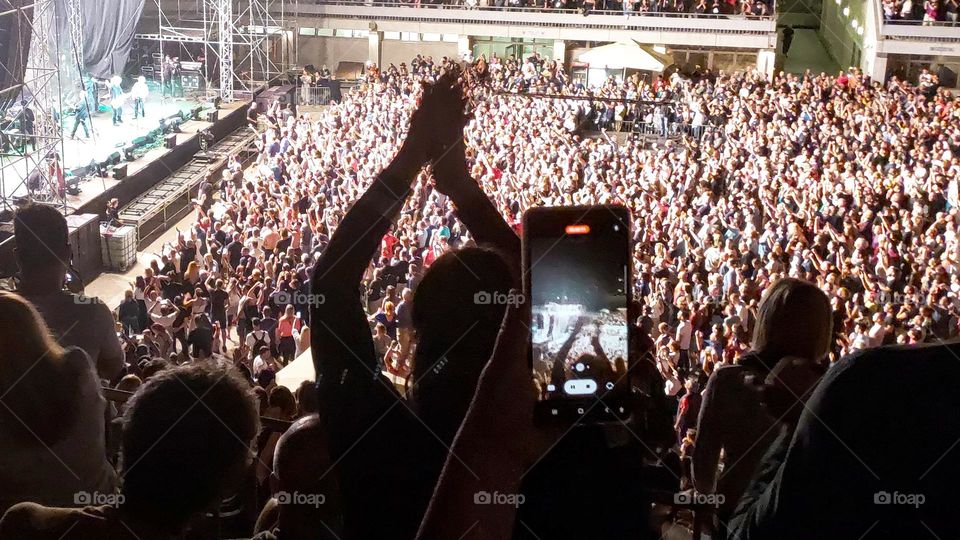 Recording a video of a musical group on the phone at a concert