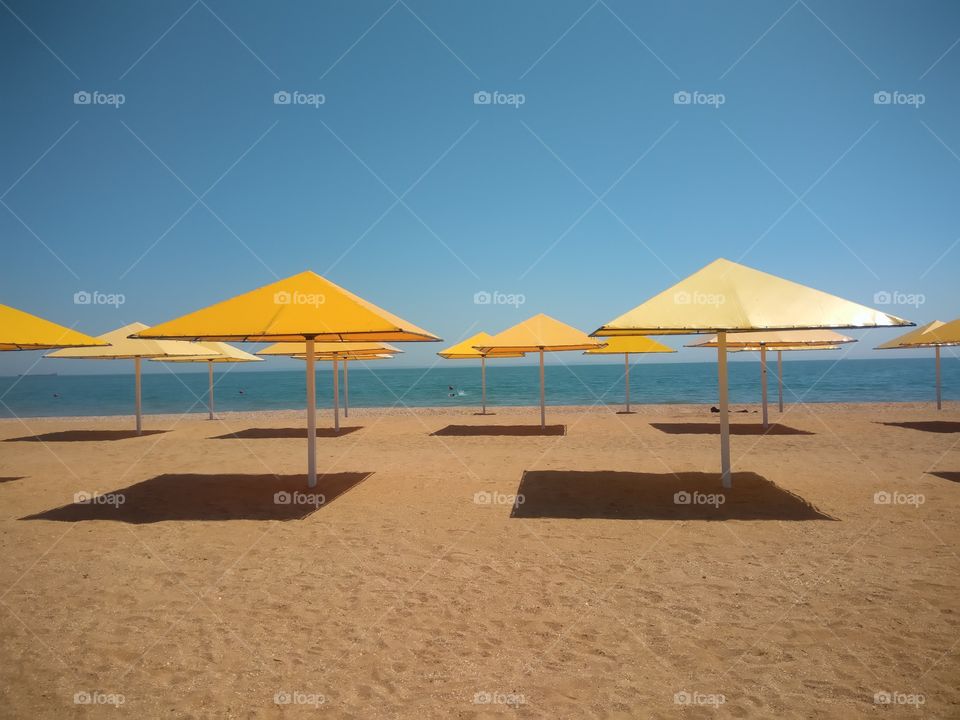 Sun umbrellas on the sandy beach in summer