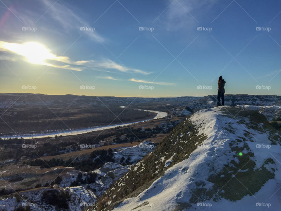 Surveying the view of the frozen landscape while hiking in Theodore Roosevelt National Park during a North Dakota winter.