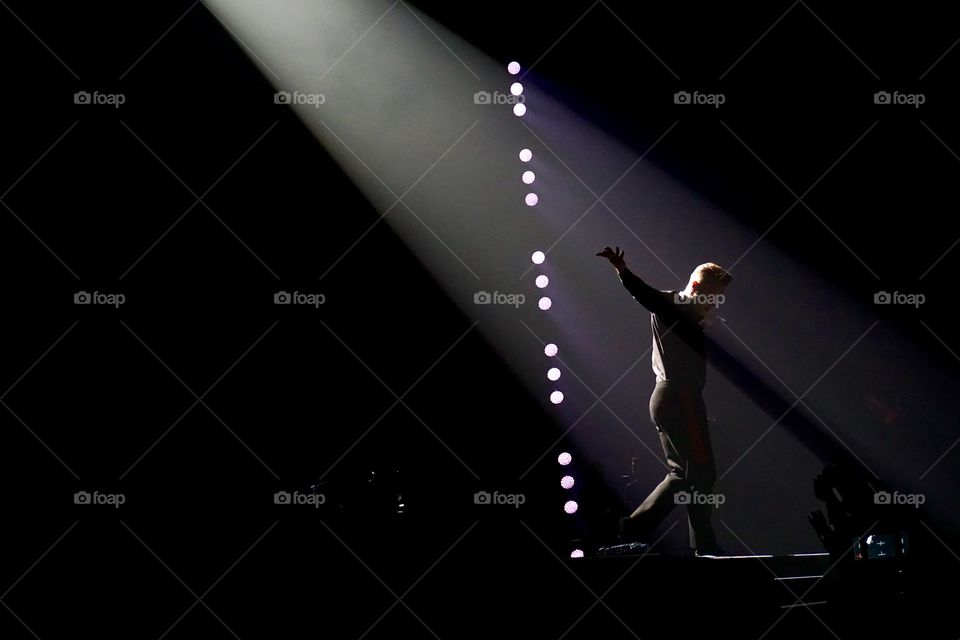 Concert ... Interesting colour photo which is black and white .. love how the light shines on his back and head and the twinkle of mobile phones in the audience