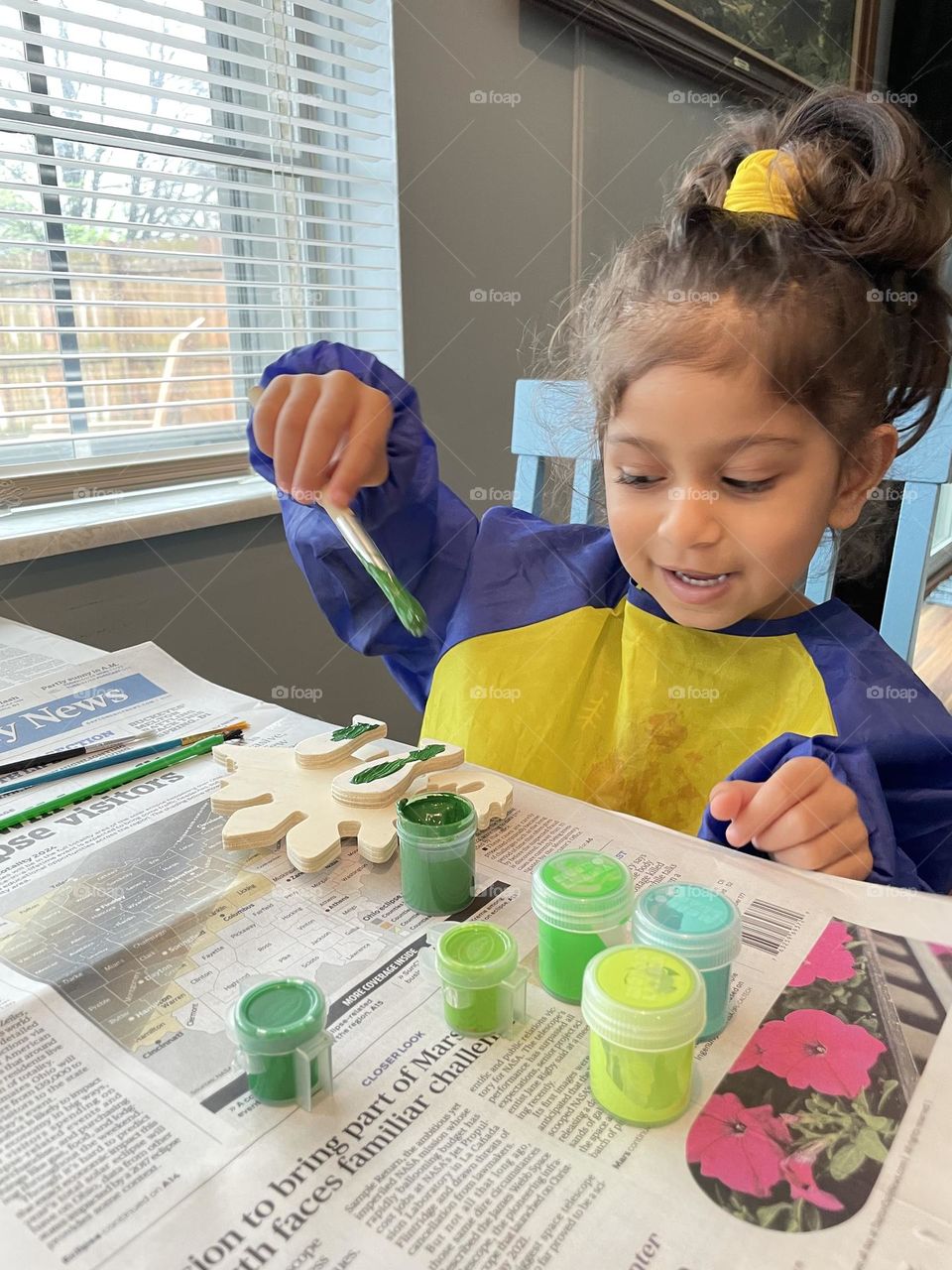 Little girl paints wooden dinosaur, making art with toddlers, painting with toddlers, green dinosaurs 