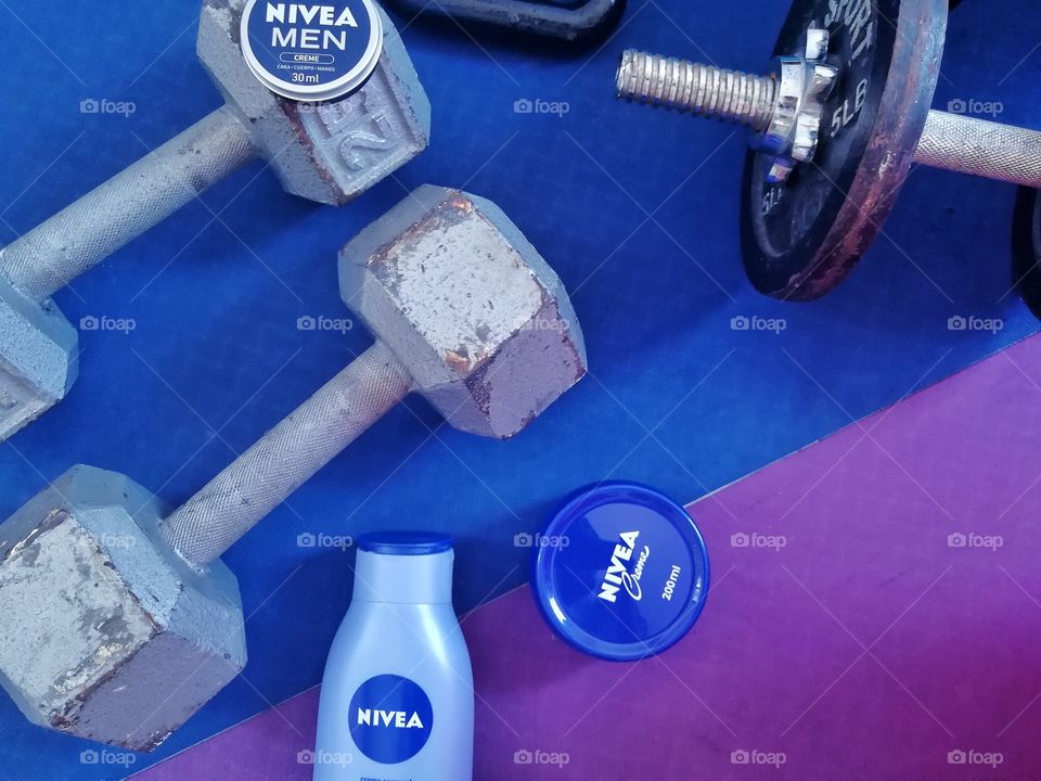 Nivea products and dumbbells on a yoga mat