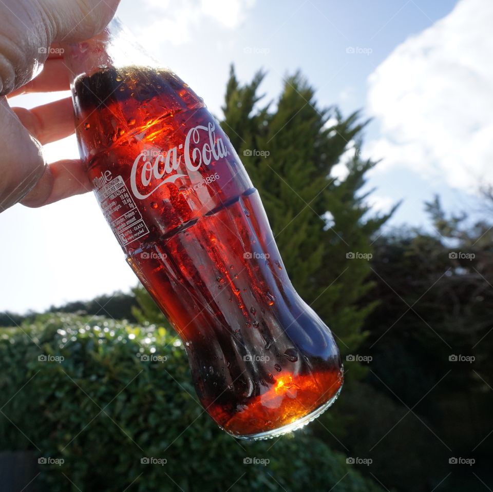 Coca Cola held up into the sky 