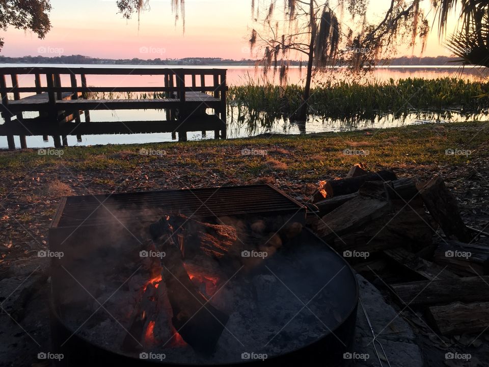 Campfire on a lake at sunset in Florida. 