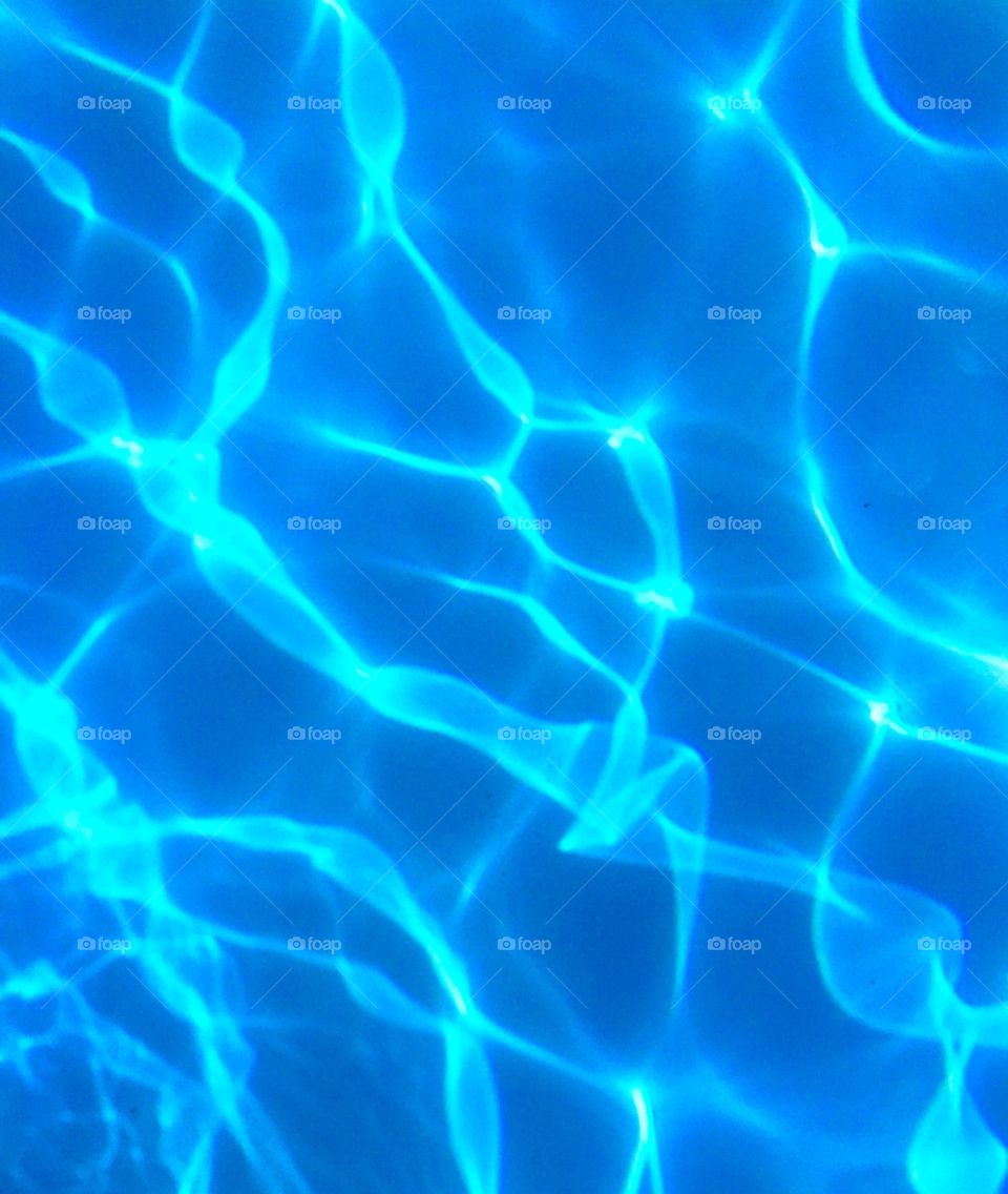 The beautiful blue water with light reflections that are crystal clear in my parents pool. 