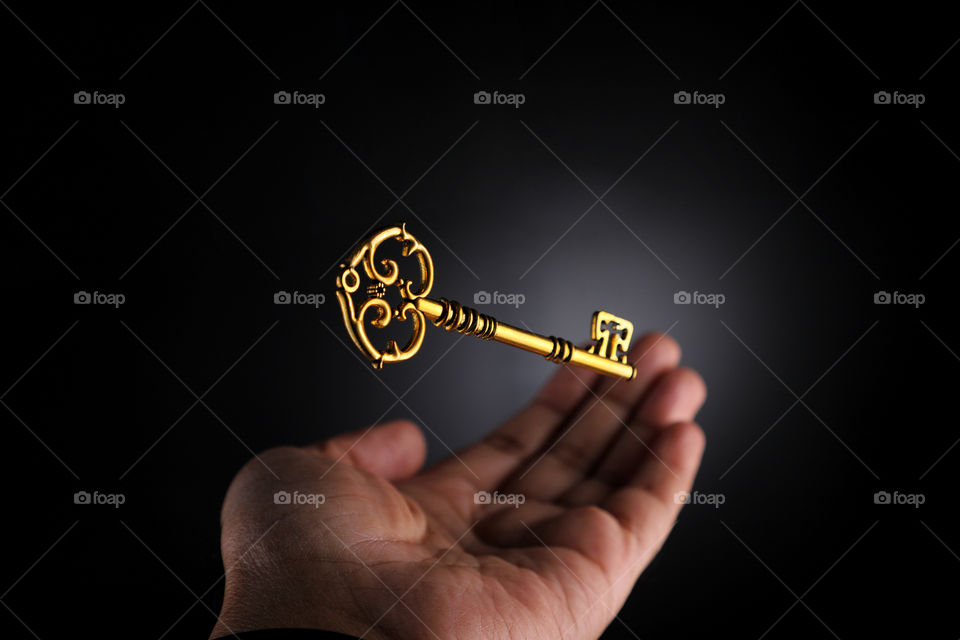 Grab the opportunity - antique golden key with a hand