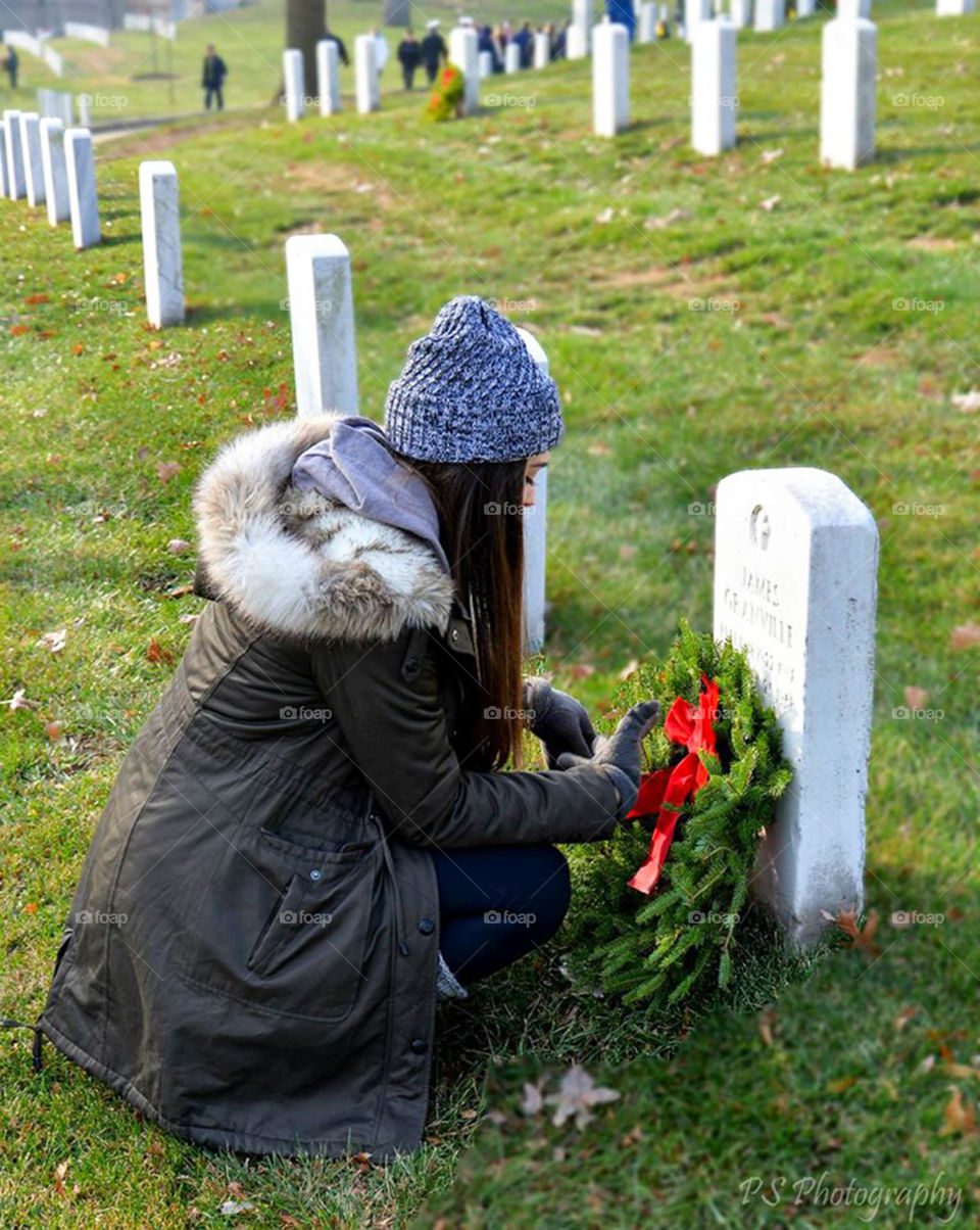 Girl honoring fallen soldier. Arlington national cemetery wreaths across America ceremony