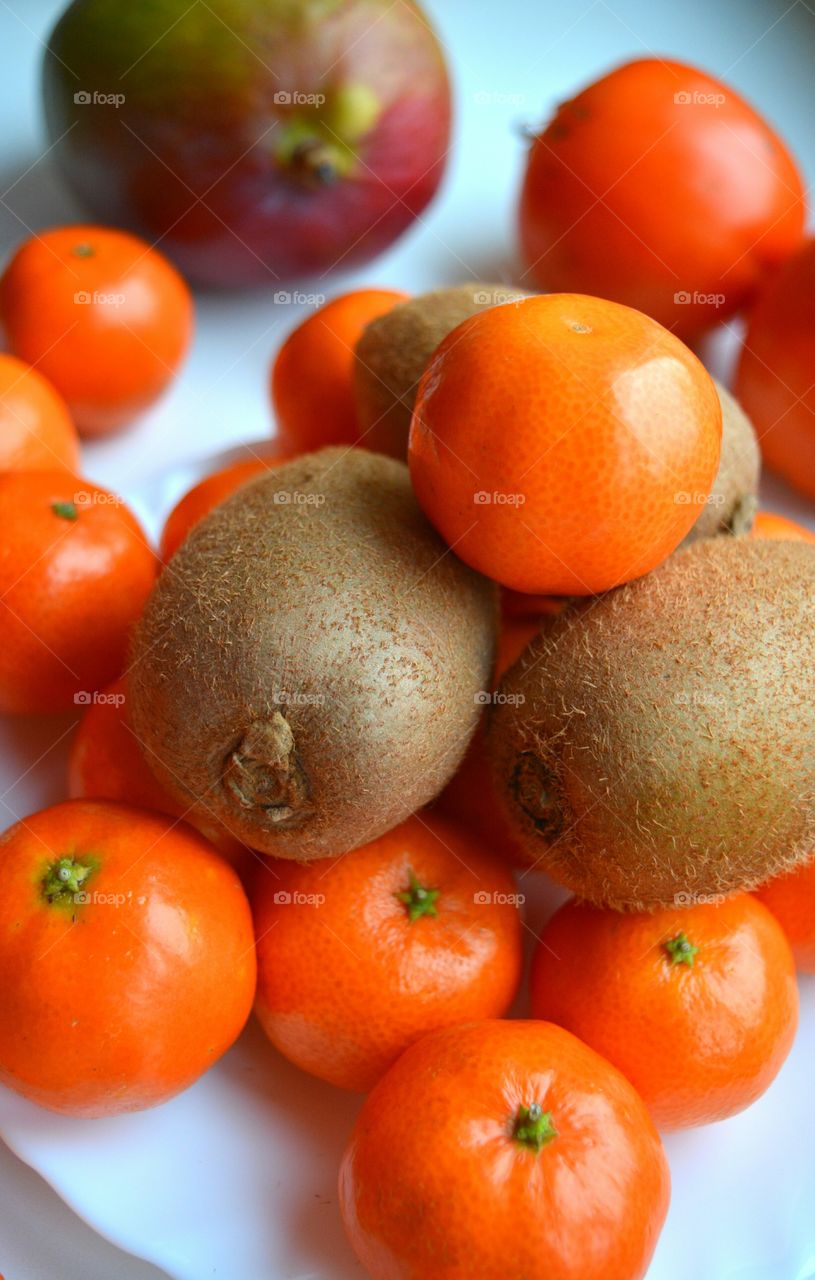 fresh tropics fruits kiwi and tangerines top view white  background