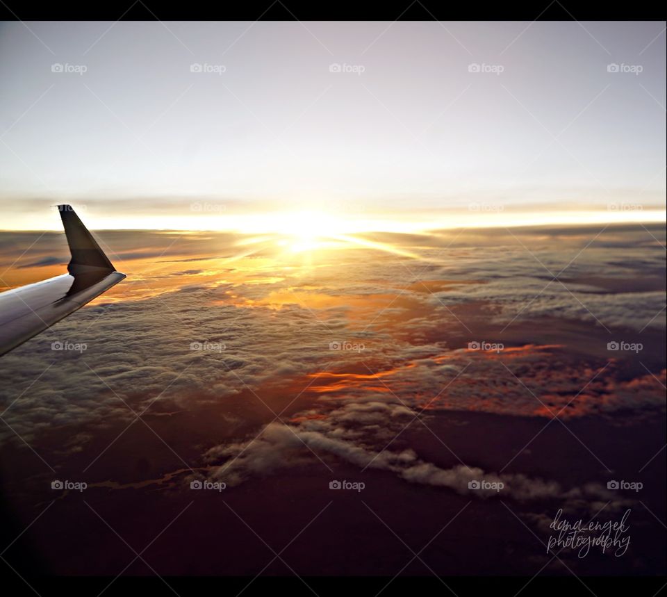 In the air with the destination in mind, the beautiful evening sun setting below is a spectacular view.