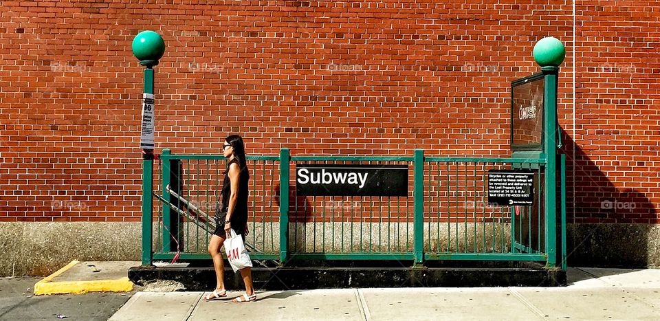A Woman Walking by a Subway . Subway Station, Chelsea, Manhattan, NYC