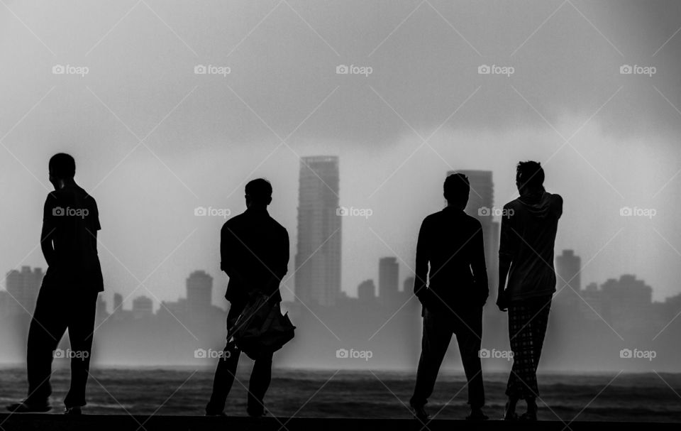 people standing at Marine drive with backdrop of buildings and sky scrappers and watching the sea