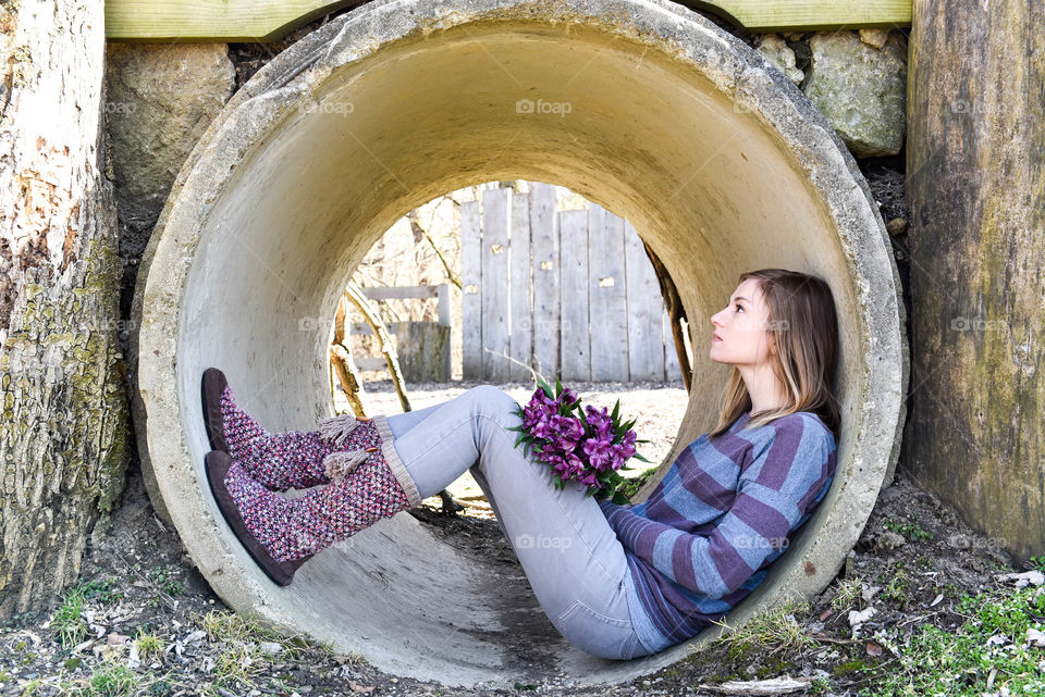 Young woman sitting in a cement cylindrical tunnel