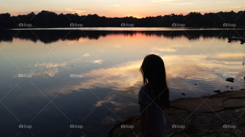 Girls silhoette watching the sunset.