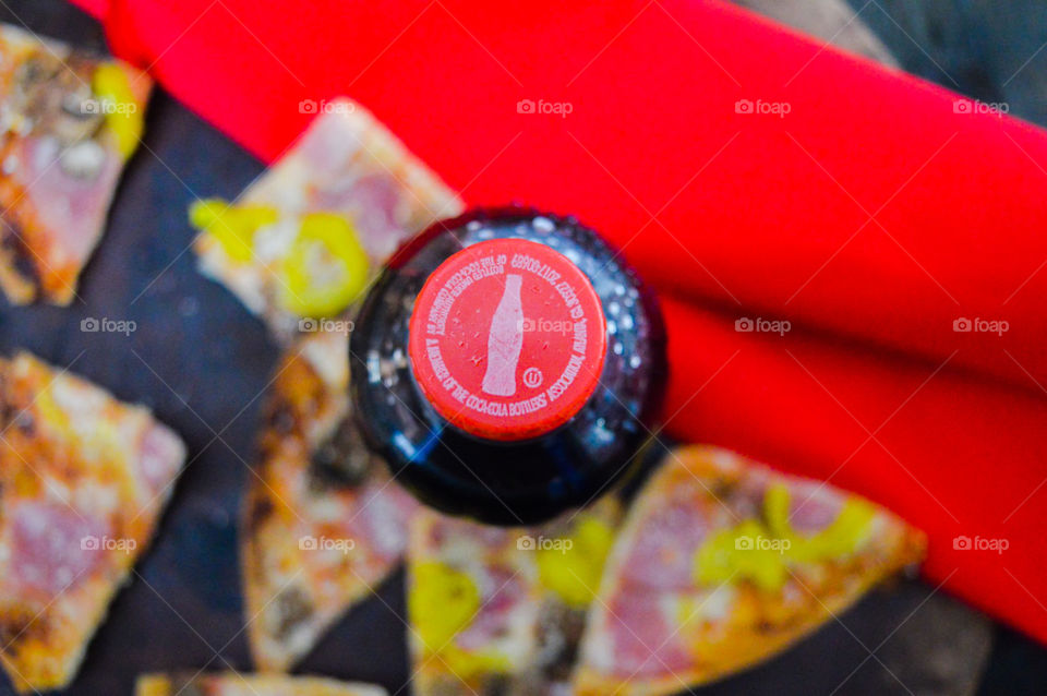 Coca-Cola and cherry Coke and Diet Coke with pizza on a rustic red background