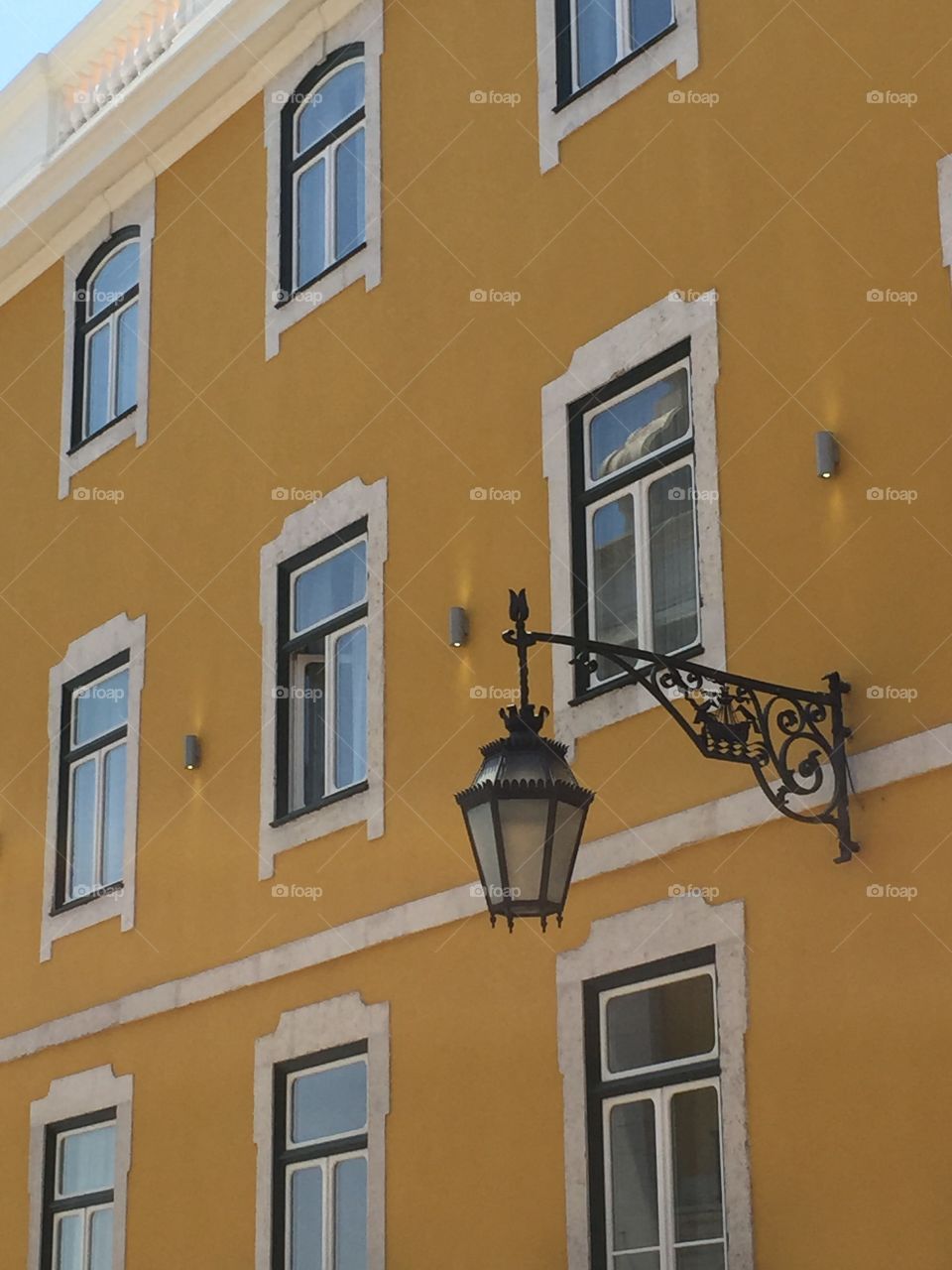 Lisbon. Loved the mustard color and the lamps along the sides of the buildings.