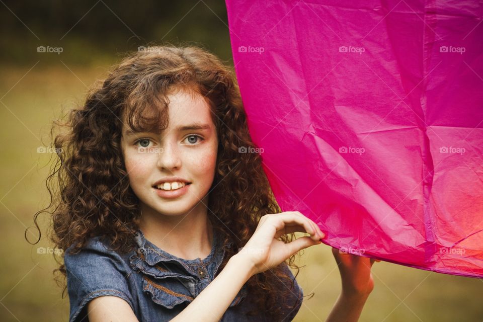 Portrait of a happy girl holding pink object