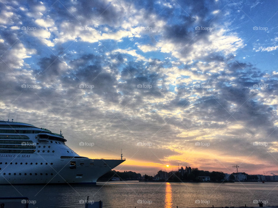 A cruise ship entering port at sunrise
