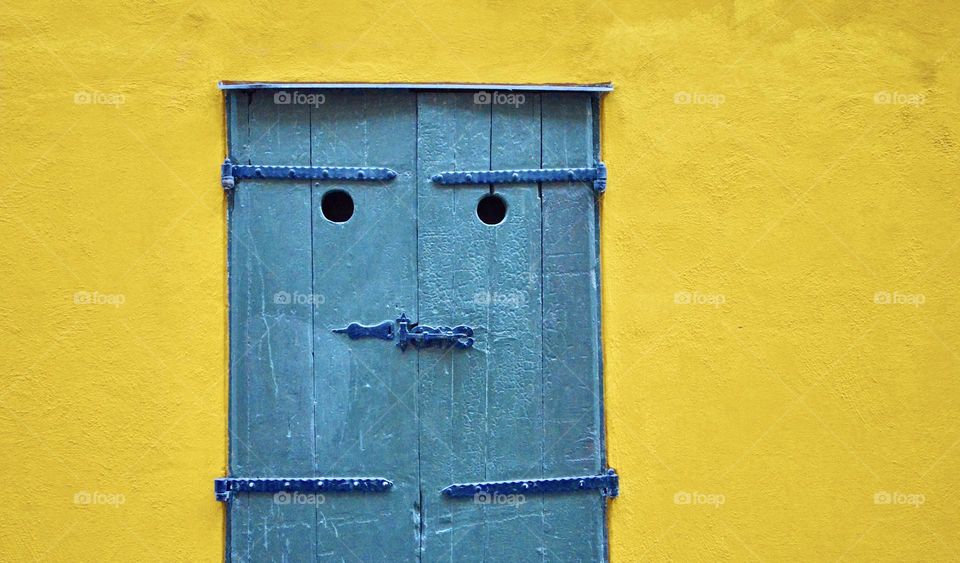 Photo of a yellow building or house with a blue door