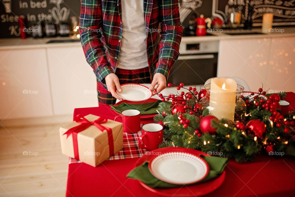 man sets a beautiful decorated winter table for a festive dinner.  Merry Christmas and Happy New Year.