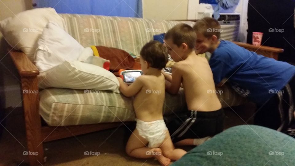 Brothers in a row watching tablet