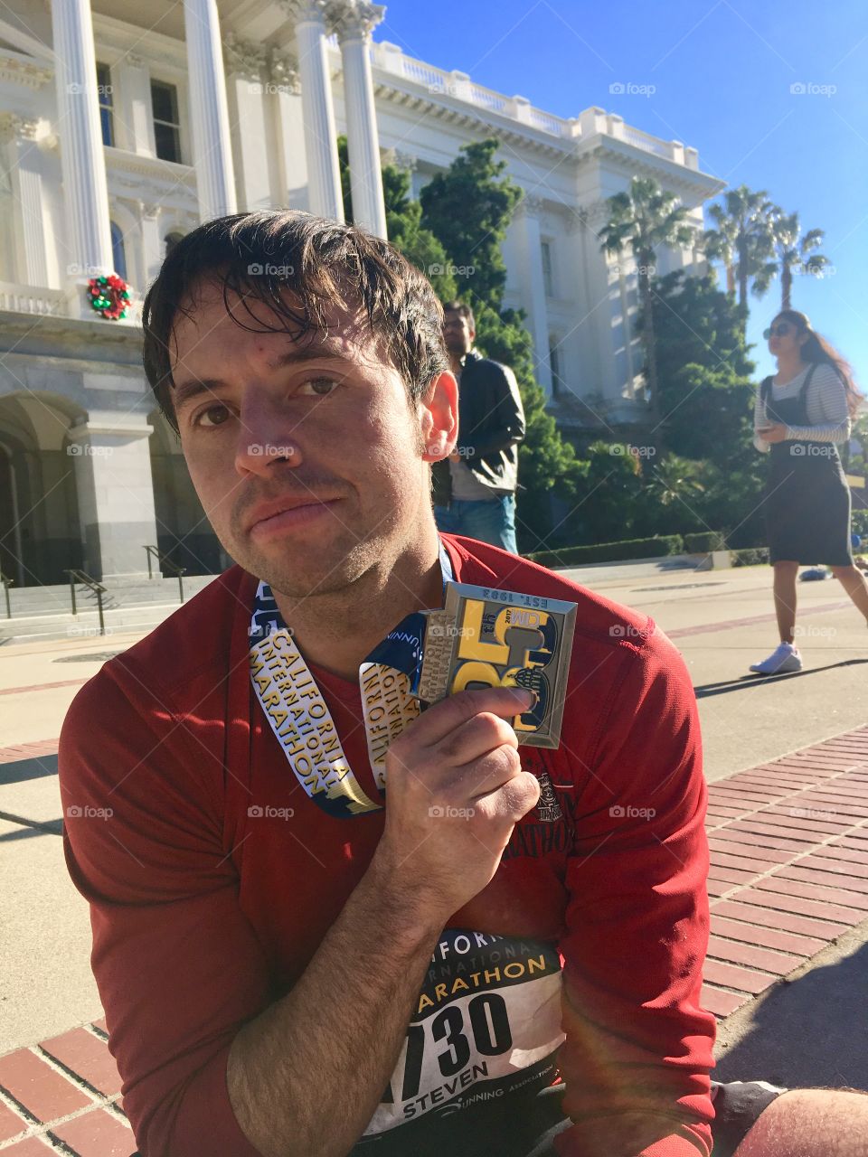 Tired man after running a marathon with his medal