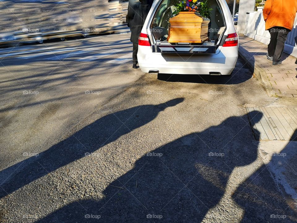 White and open hearse with coffin inside