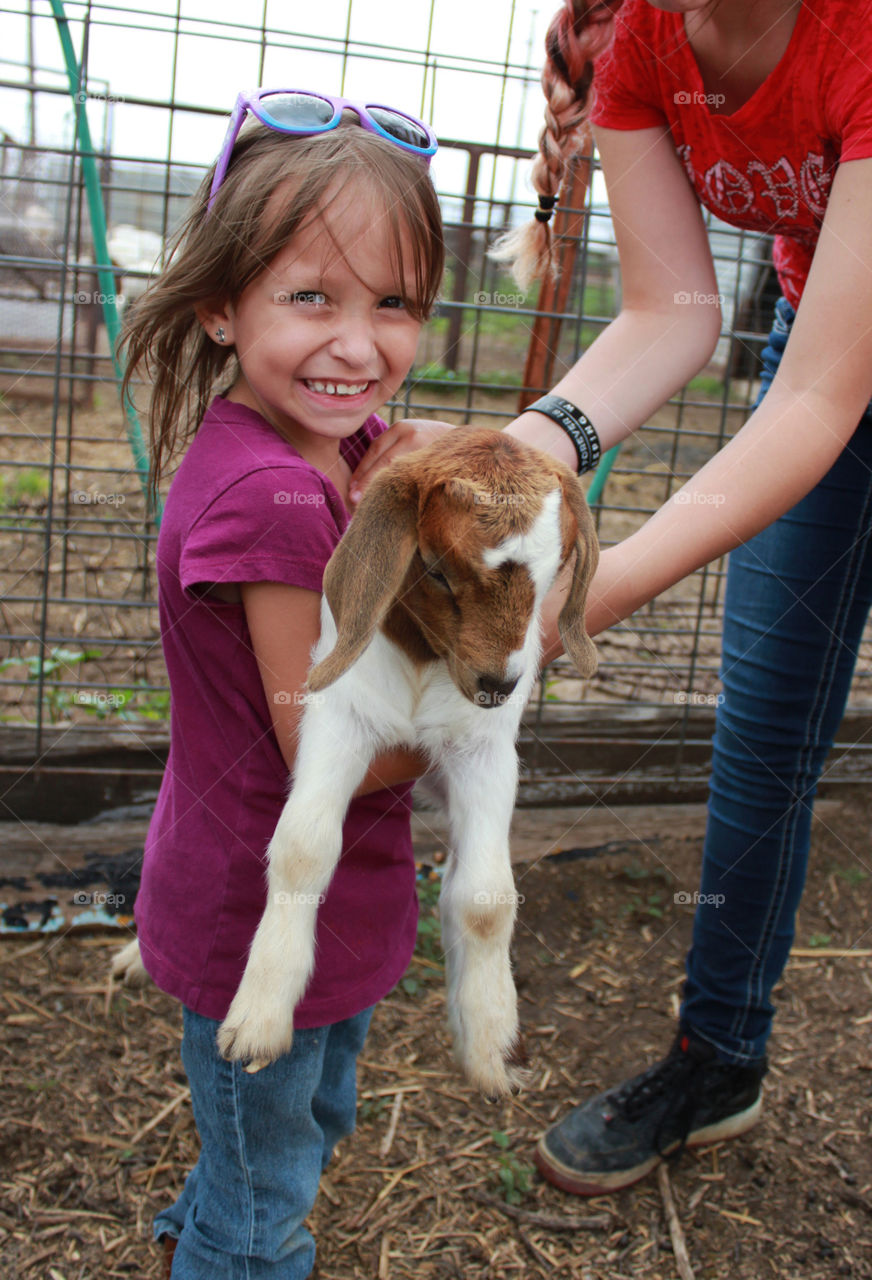 Girl holding a young goat