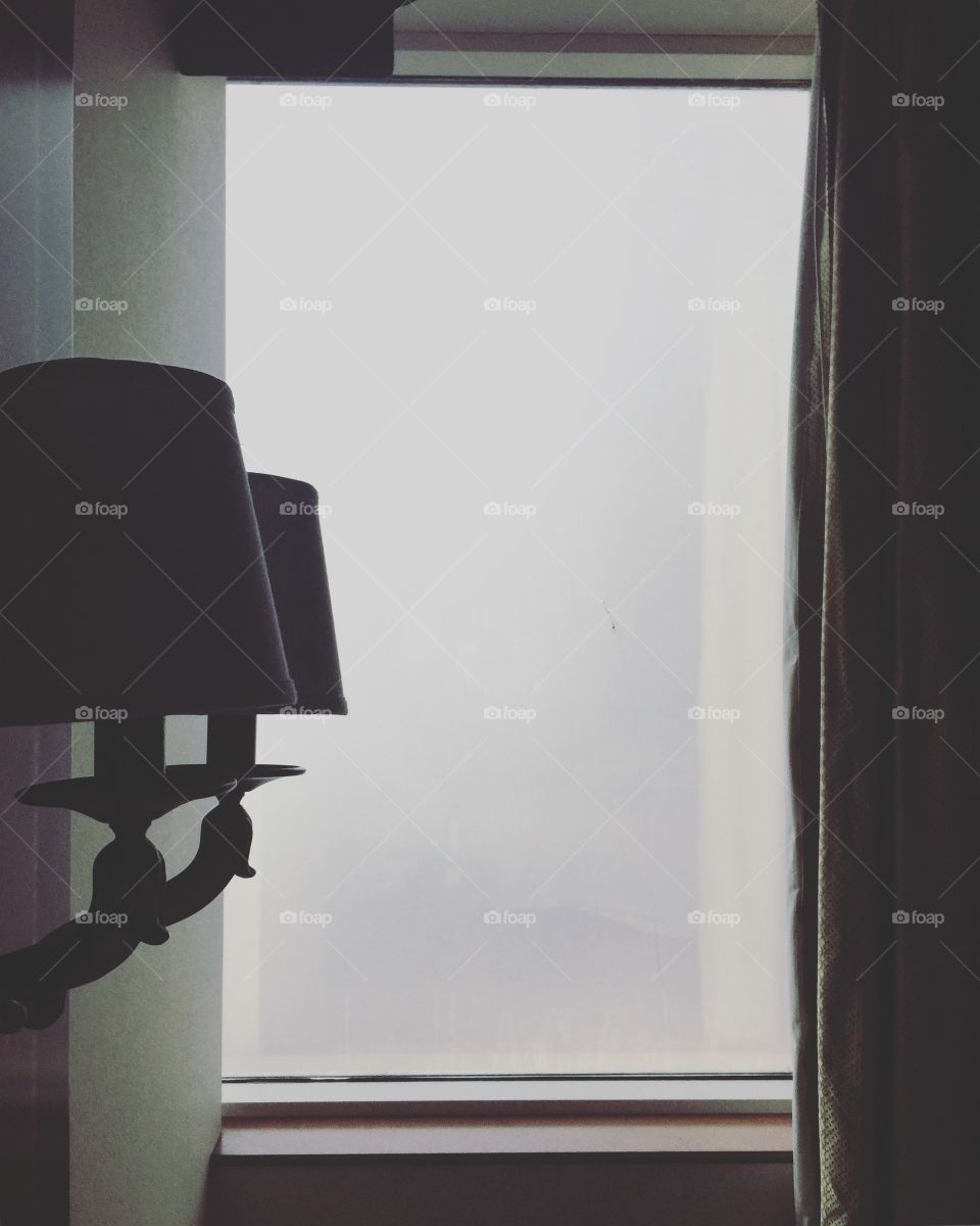 Hotel room lamp and window view of thick white fog in Abu Dhabi, United Arab Emirates 