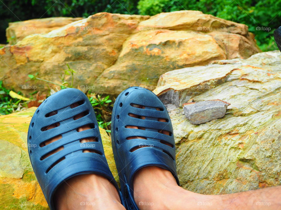 Closeup foot of traveler on the rock with nature around mountain