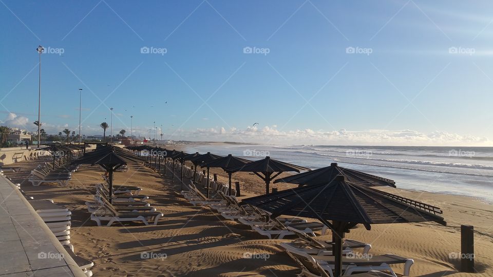 Empty beach umbrellas on sandy beach