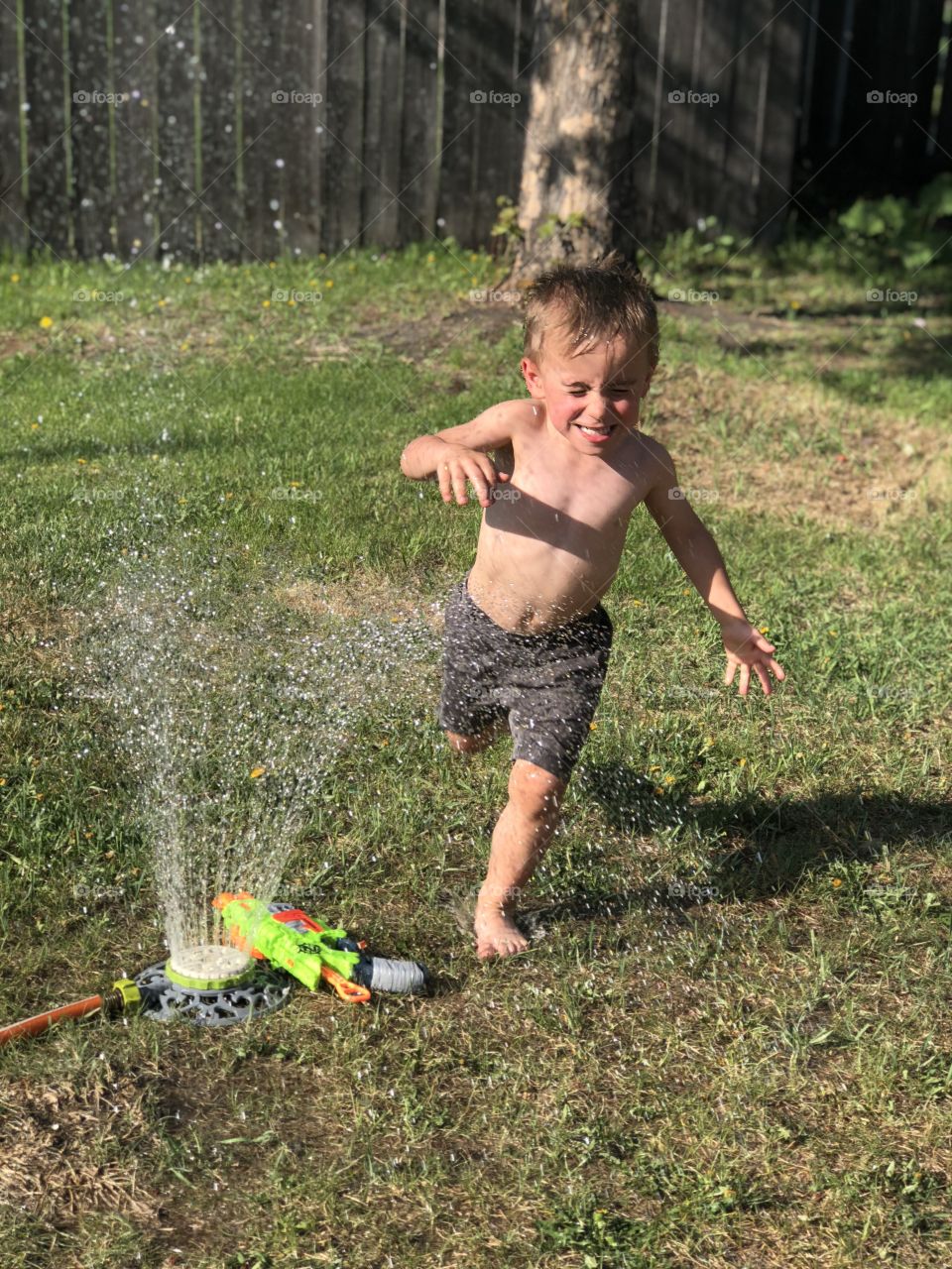 Toddler playing in the sprinkler. 