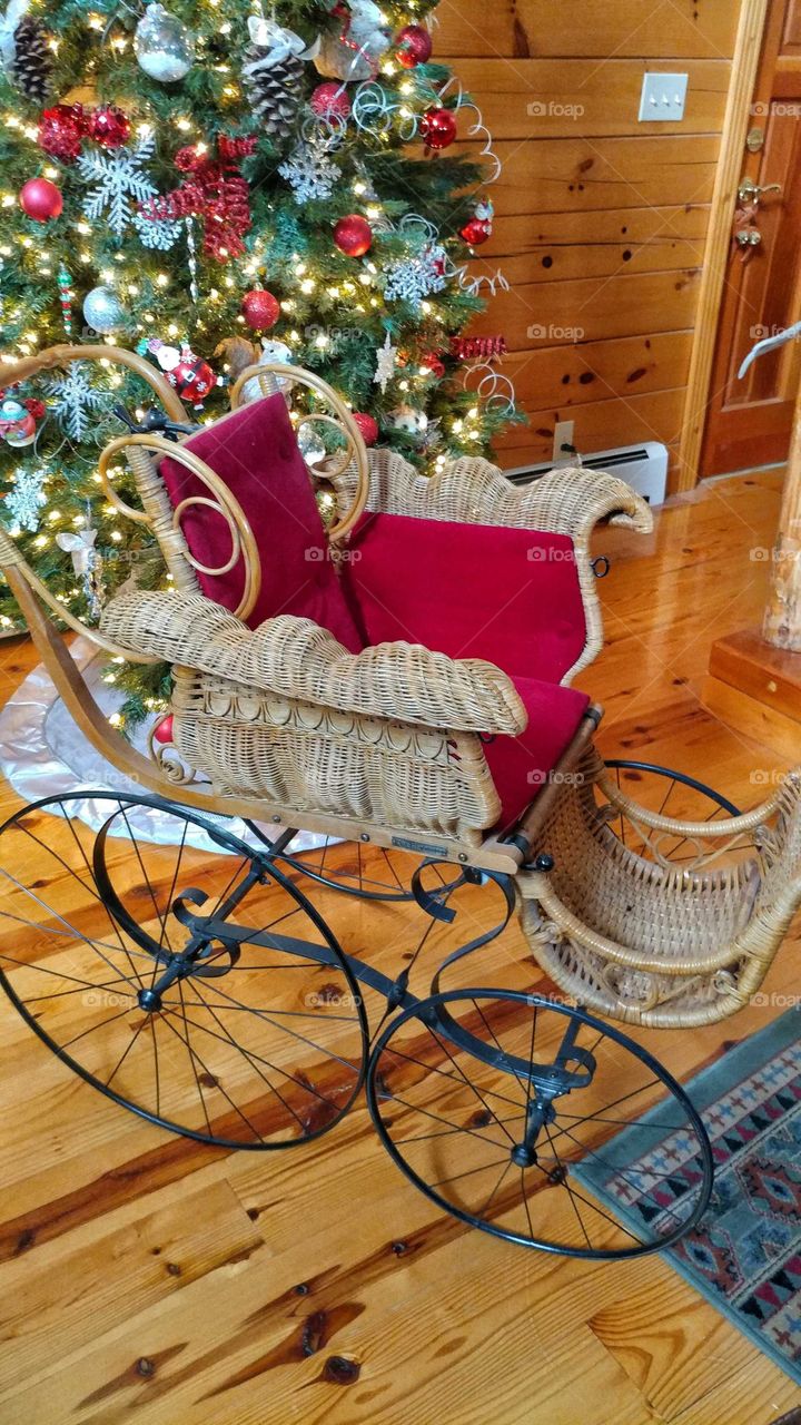 Vintage baby stroller under the Christmas Tree.