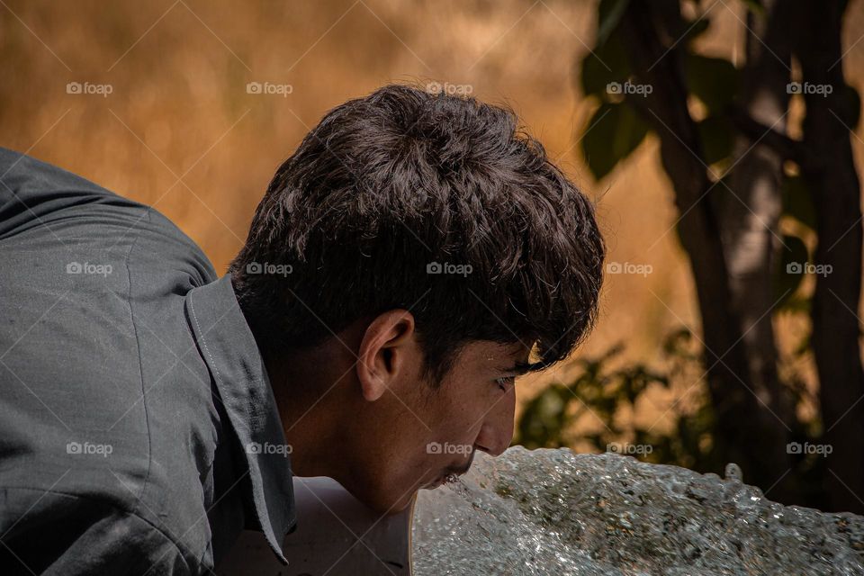 boy Drink Water from water pump in summer