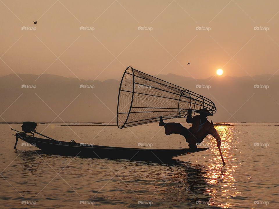 Traditional Burmese fisherman at sunrise on Inle Lake
