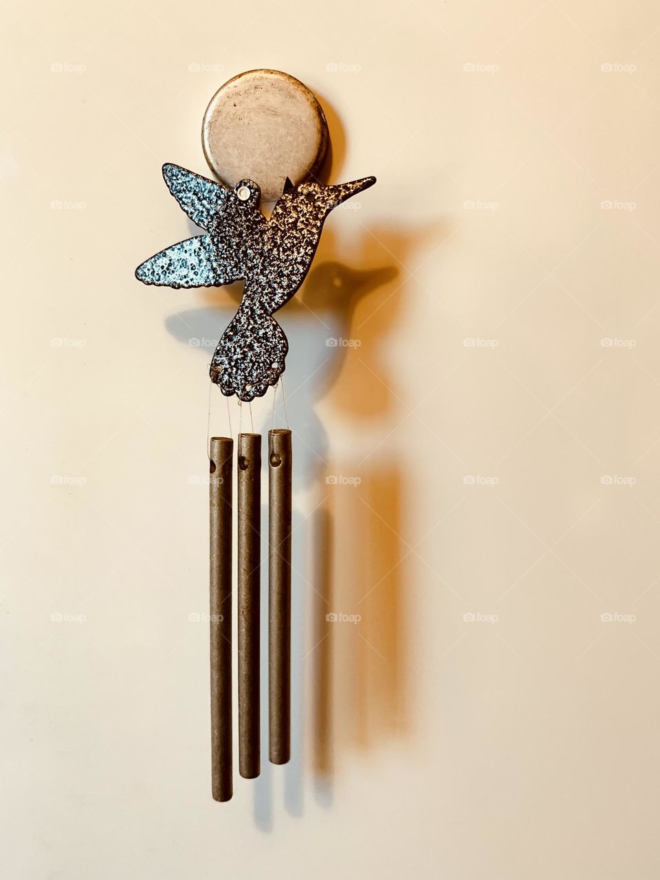 Refrigerator magnet with Bird design with three chimes and its shadows on the Fridge. 
