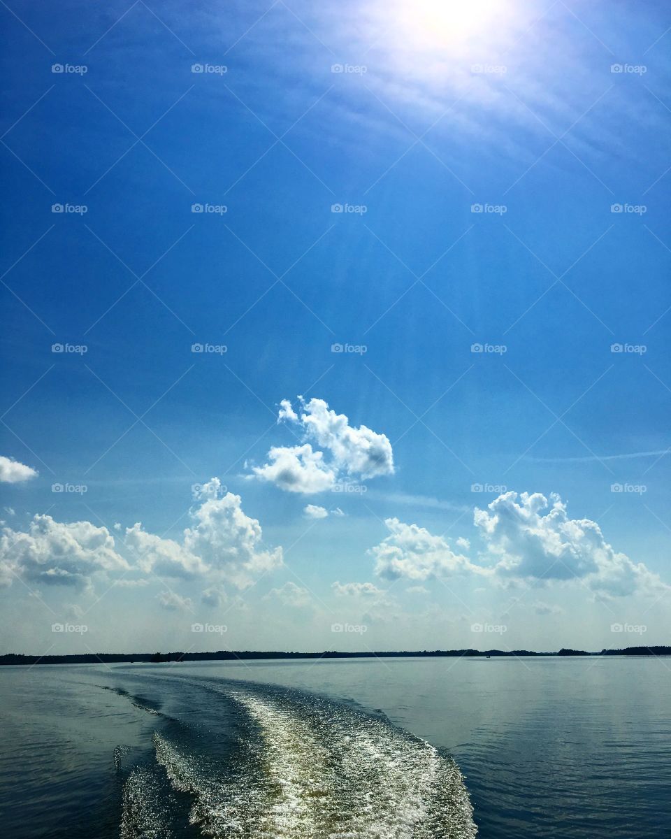 Beautiful Day on the lake! Sun shining, lake glistening, and the shore in the distance. Traveling by boat is peaceful and exhilarating! Look around and wear sunscreen!