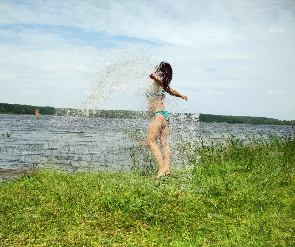Девушка на озере в брызгах воды