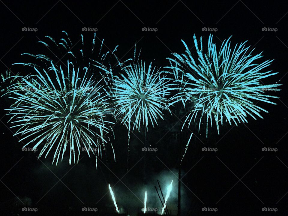 Dazzling blue fireworks burst in the night sky.