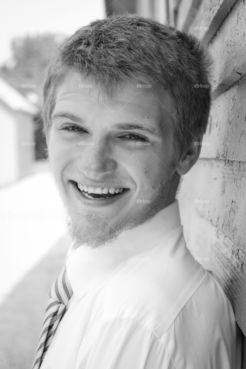 Smiling man standing near wall