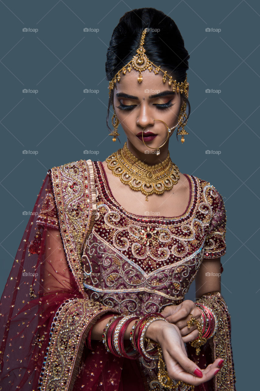 Beautiful indian bride on grey background