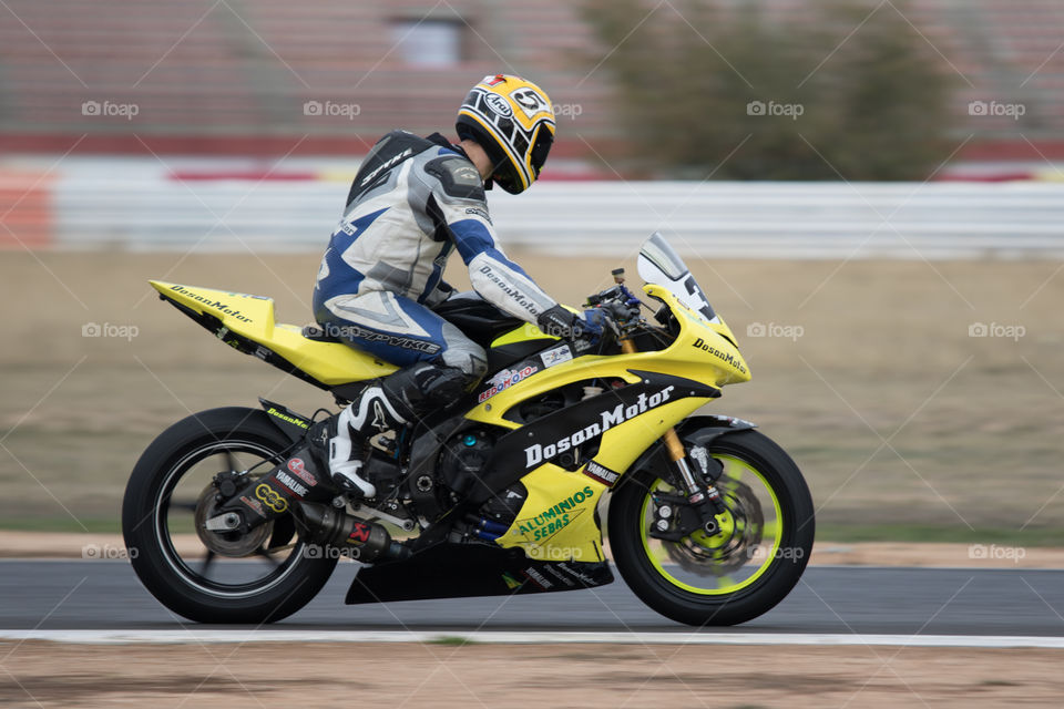 Yellow sportbike and rider on circuit