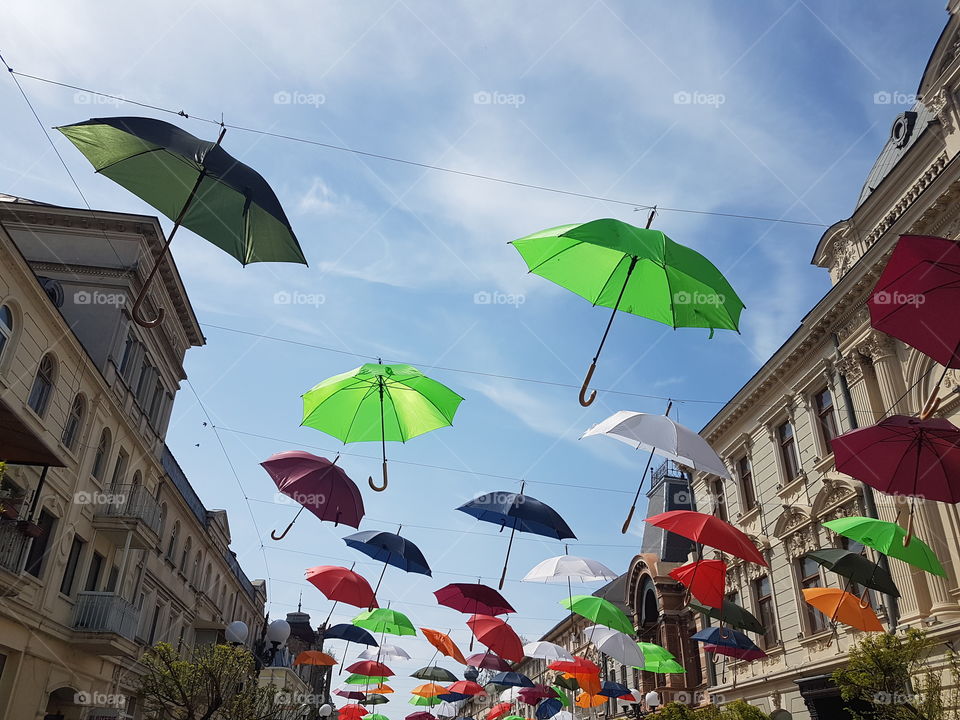 Colorful umbrellas in the old city sky