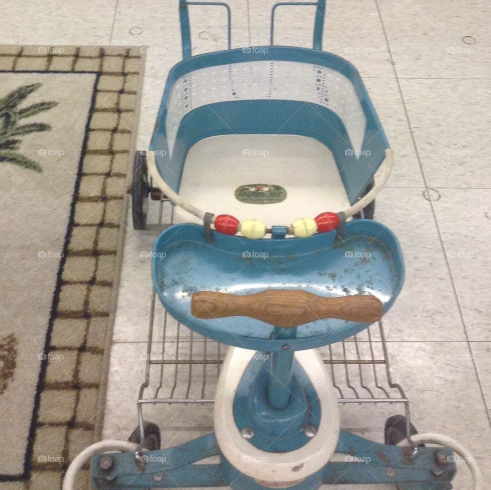 This is an antique stroller displayed and for sale in an antique store.