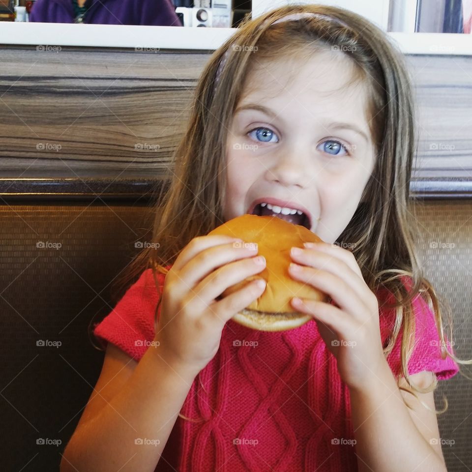 Close-up of a girl eating burger
