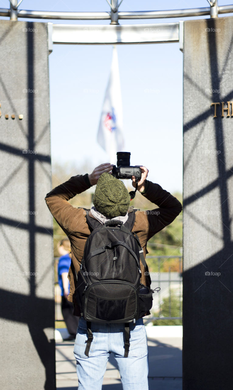 Rear view of man holding camera